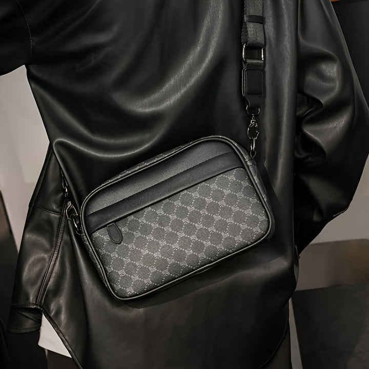 Sacoche messenger grise à motif portée en bandoulière sur veste en cuir noire., 46194058002656,46194058035424,46194058068192,46194058100960