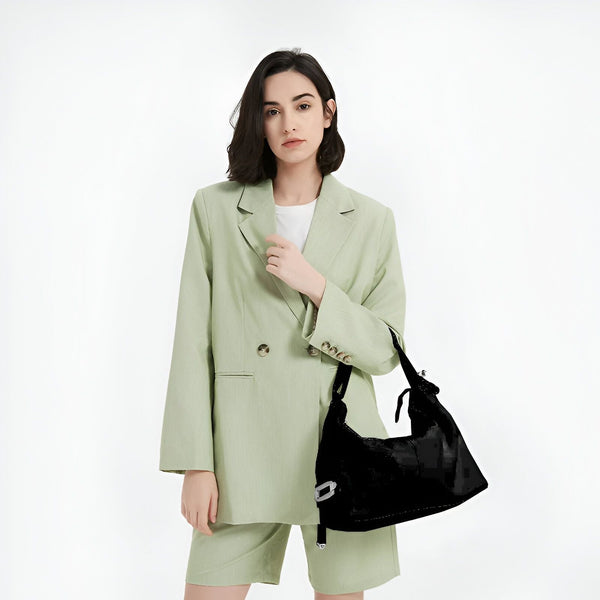 Femme en tailleur short vert clair portant un sac à main noir., 46193865228512